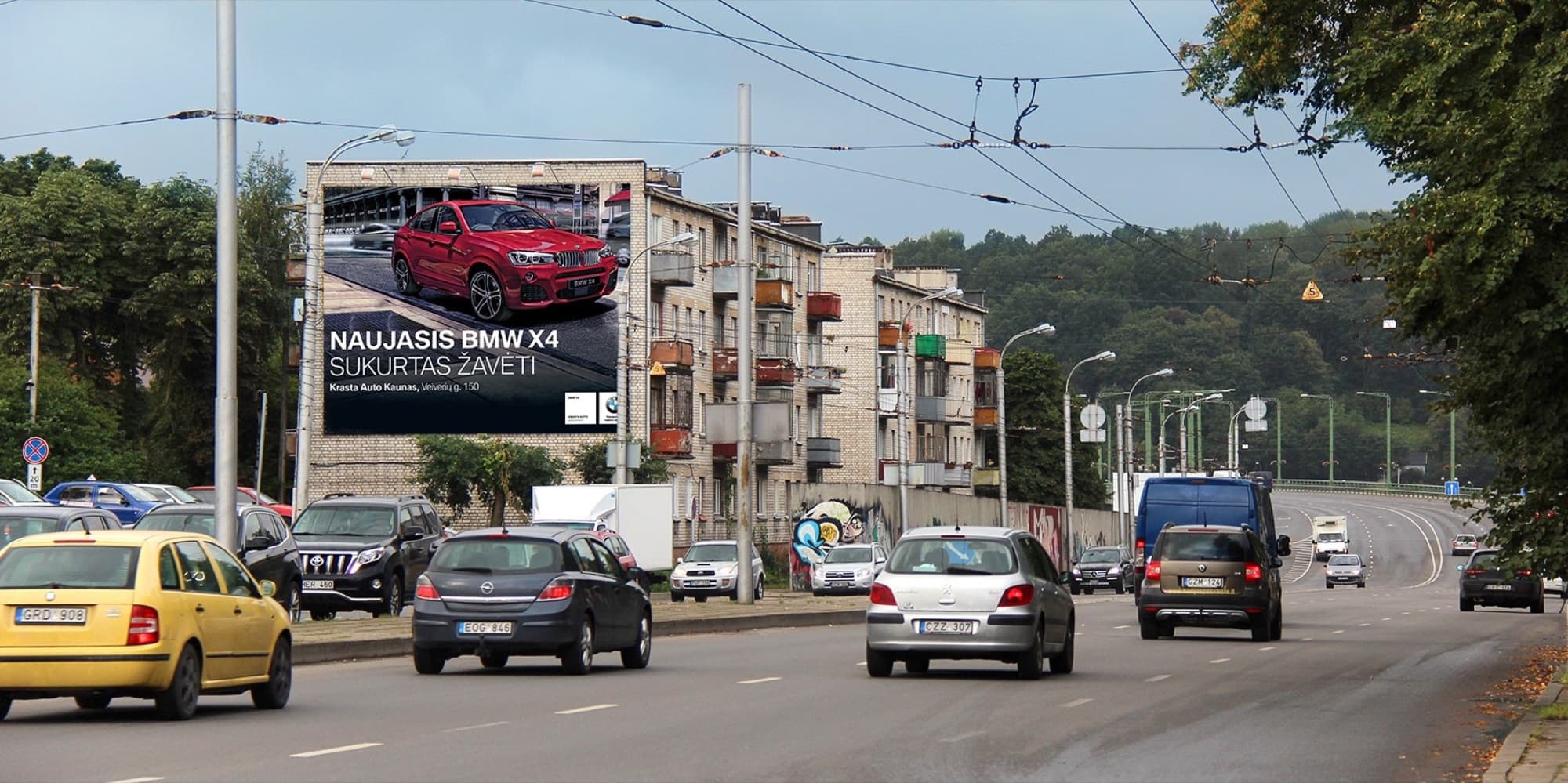 Reklameplakat ved Čiurlionio g., nær jernbanestationen og torvet, mod centrum, Kaunas — Reklamos stendas Kaunas