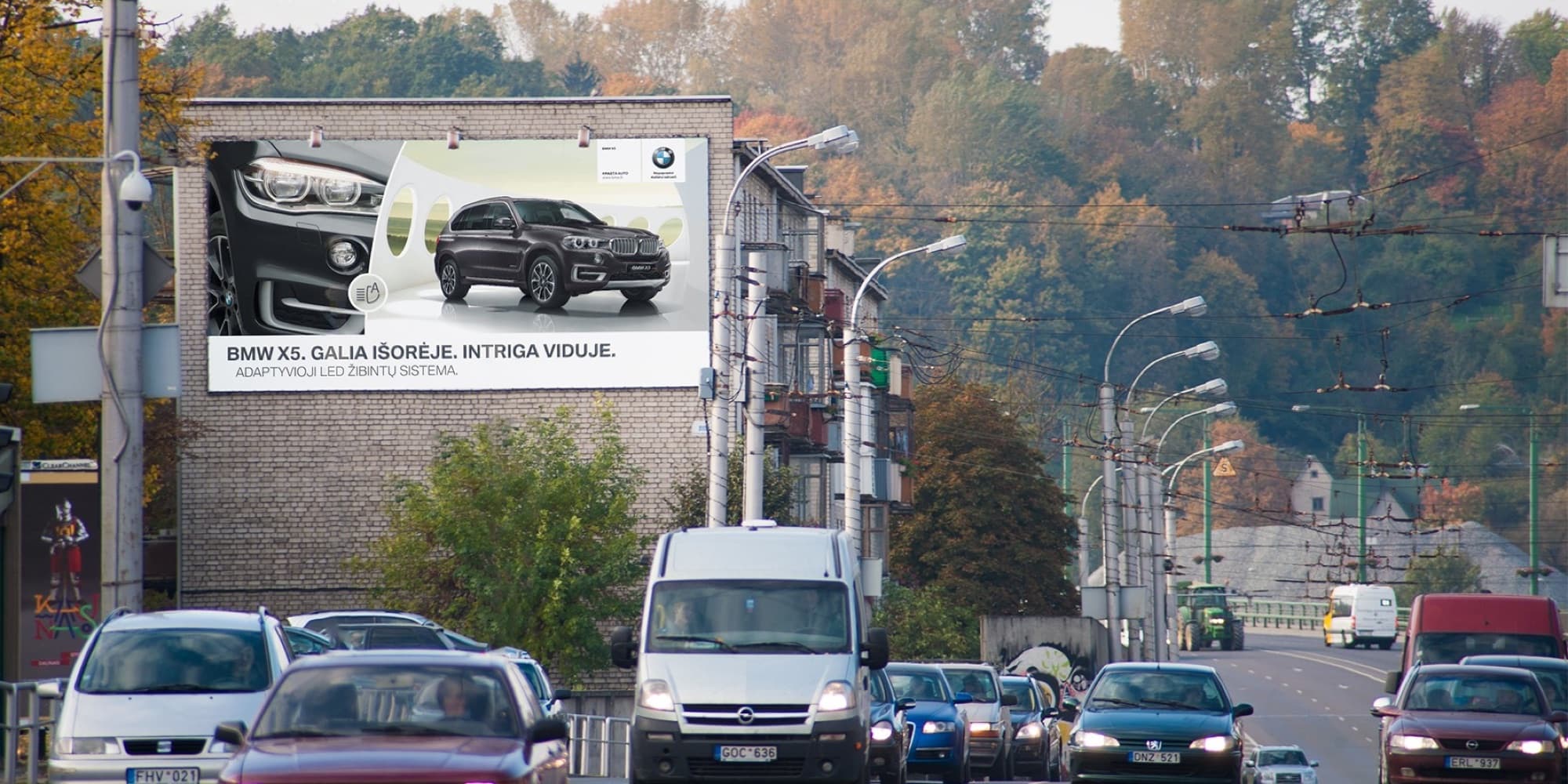 Reklamskylt på Čiurlionio g., nära järnvägsstationen och torget, mot centrum, Kaunas — Reklamos stendas Kaunas